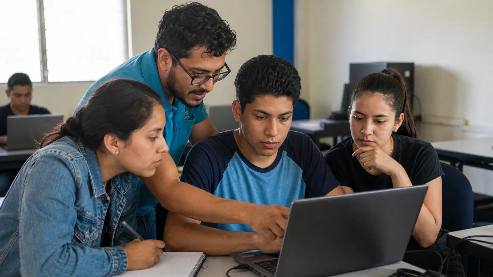 A mentor and three learners review a programming exercise together at a laptop.