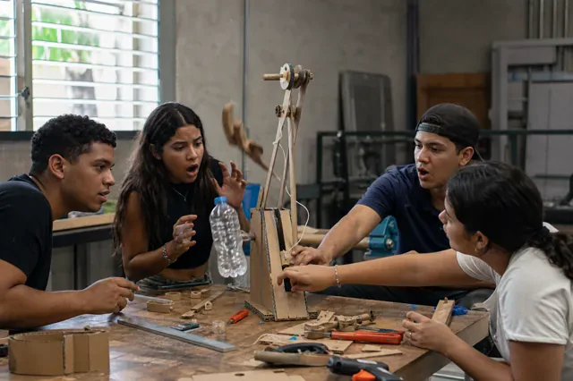 Equipo prueba y ajusta un mecanismo construido con cartón.