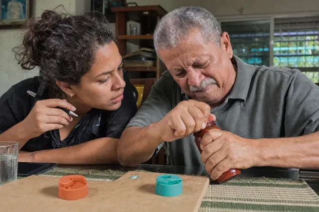 Diseñadora observa a un usuario probar un envase difícil de abrir.