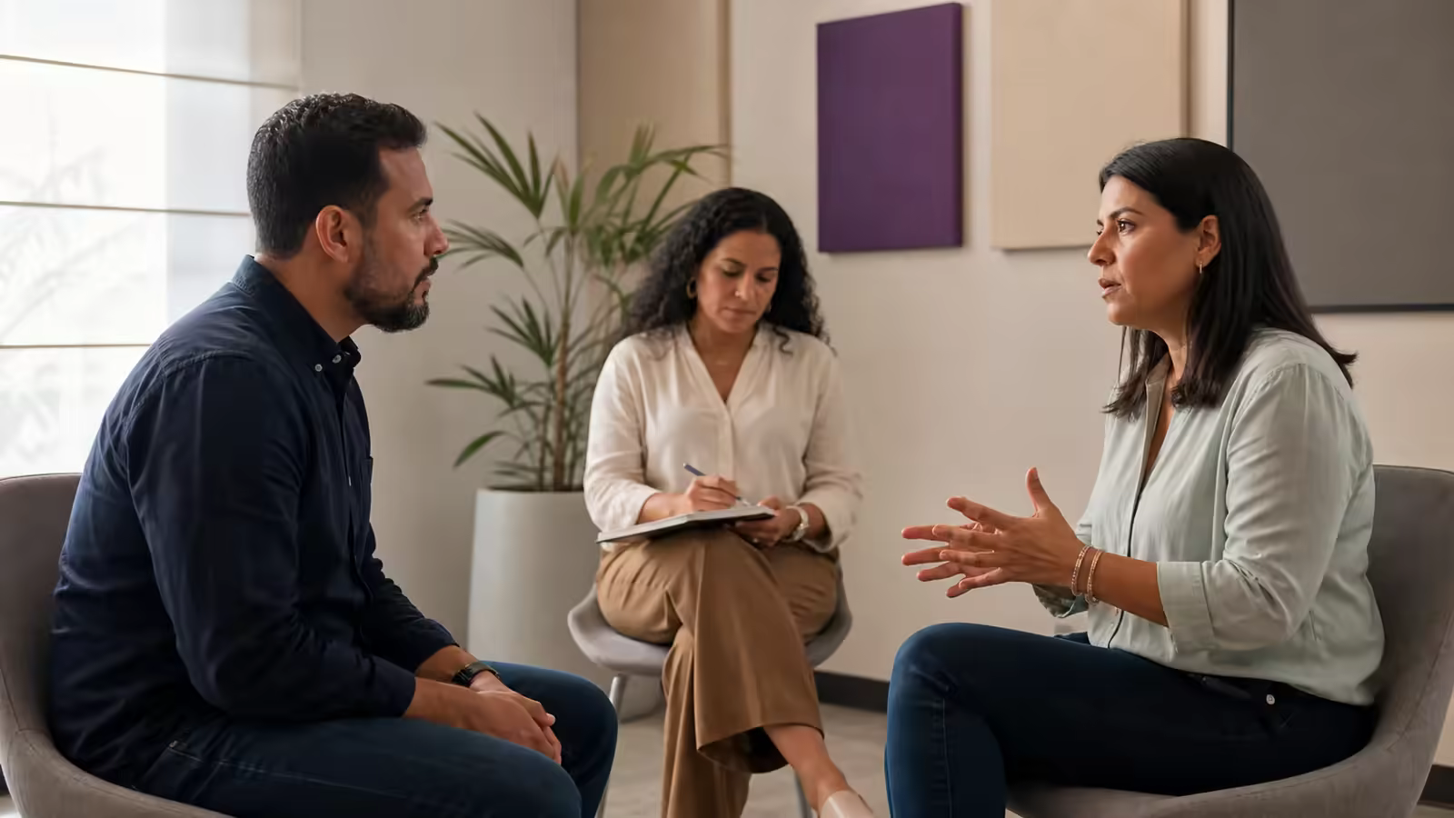 Dos colegas practican una conversación laboral atenta mientras una facilitadora observa.
